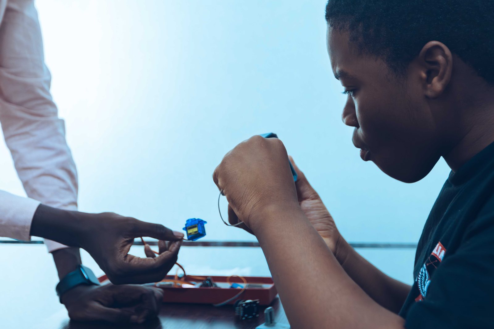 A volunteer and student working closely on a STEM kit